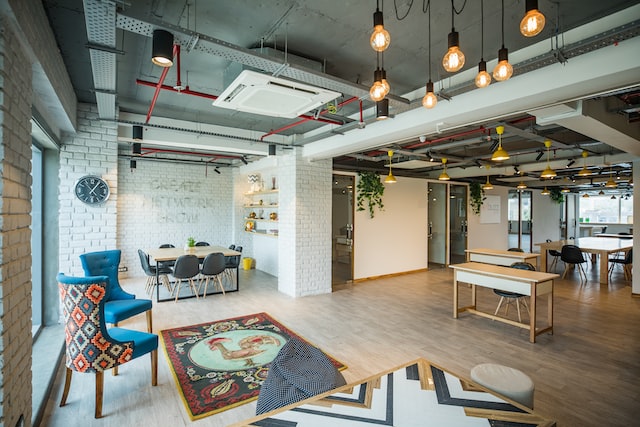 open plan office space with homely furniture and a small rug on the floor