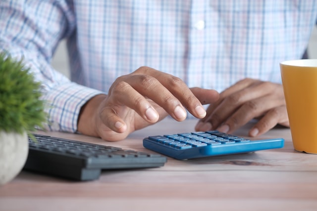 man entering numbers into a calculator