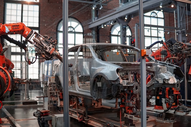car being assembled by automated robotic arms
