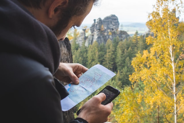 traveler using a smartphone to guide himself through a forest