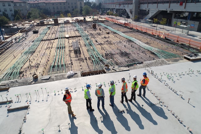 seven engineers overlooking the foundations being laid for a large building