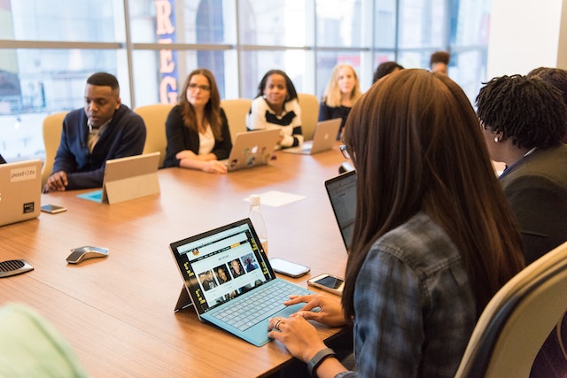 colleagues sitting around a meeting desk discussing an office move