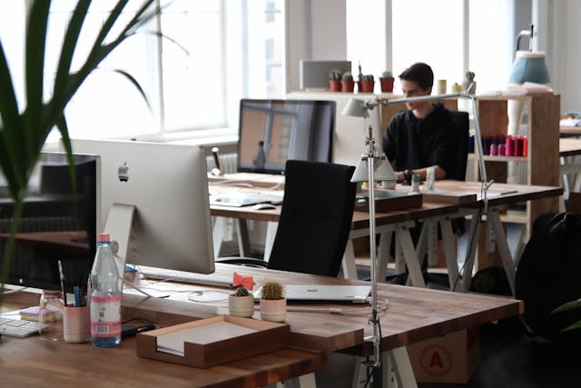 A man works alone at a modular desk in a flexible workspace. Image at LondonOfficeSpace.com.