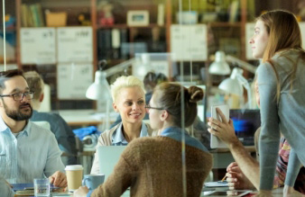 Four colleagues having a meeting behind glass